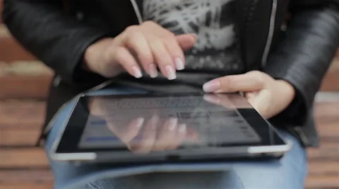 Women typing on a tablet computer in the park Stock Footage 68732269