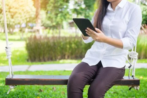 Women uses tablet for working while lying on a sunbed in garden. Foto stock
