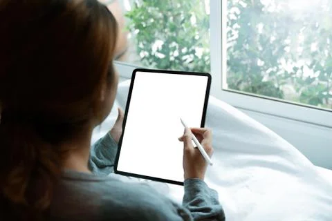Women using digital tablet on bed in morning Foto stock