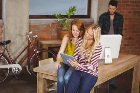 Women using digital tablet while man working on computer Foto stock