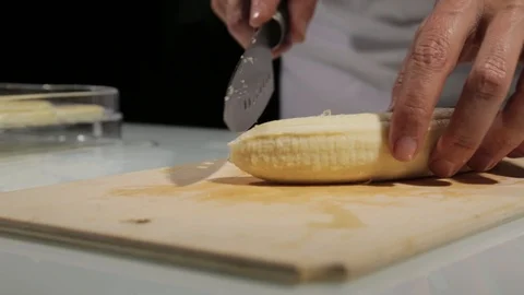 Women using kitchen knife slide cut banana on wooden cutting board. Slicing Video stock 113908109