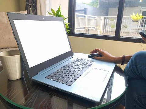 Women using laptop computer working at home with blank white desktop screen. Stock Photos