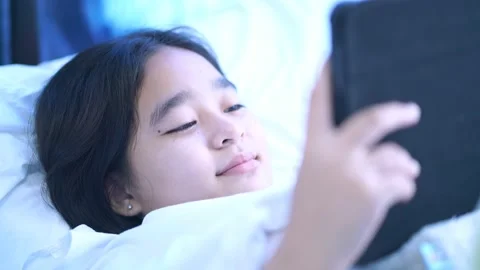 Women using mobile phones in bed, Girls playing tablets in bed in the bedroom 動画素材 227117853