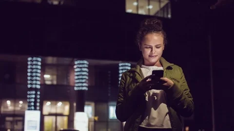 Women using smart phone while walking in the city at nigth. Urban people Stock Footage 74959151