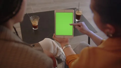 Women using tablet with green screen, talking and drinking coffee Stock Footage 244601802