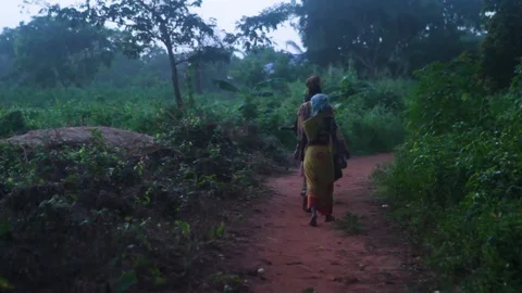 Women walking on the dirt path surrounded by green bushes on both sides Stock Footage 77445108