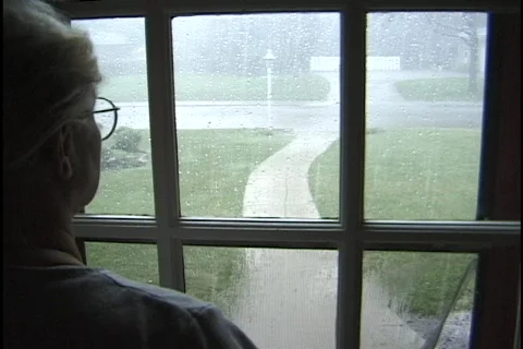 A women watches the rain outside the window. Stock Footage