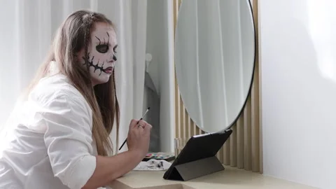 Women watching tutorial of Halloween makeup in tablet. Stock Footage 292616991