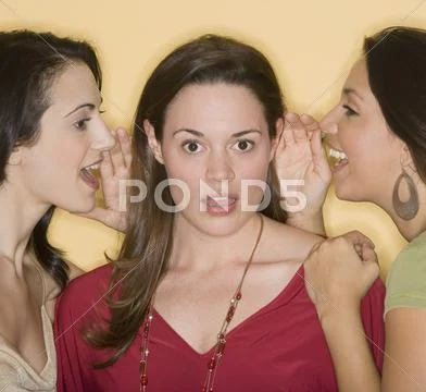 Women whispering secrets to friend Stock Photos