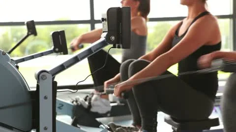 Women working out on rowing machine Stock Footage 12282445