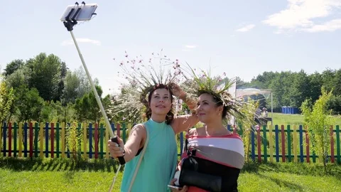 Women with wreaths herbs make selfie photo on ethnic festival, young people take Stock Footage