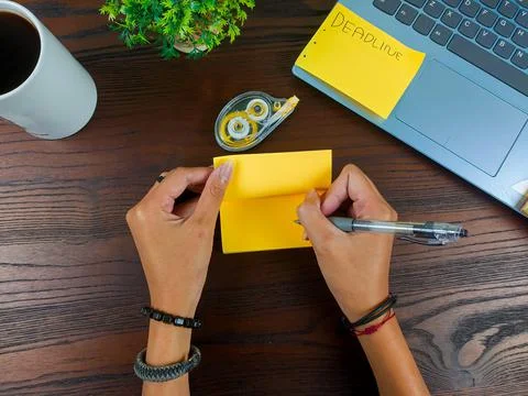 Women write in yellow notes, mock up yellow notes. Women's hands write notes Stock Photos