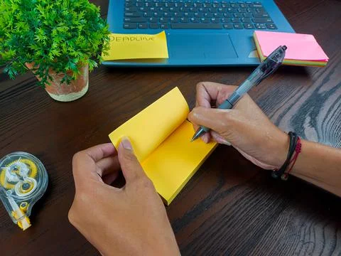 Women write in yellow notes, mock up yellow notes. Women's hands write notes Stock Photos