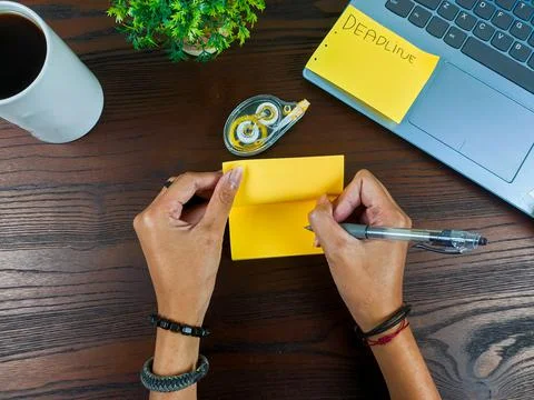Women write in yellow notes, mock up yellow notes. Women's hands write notes Stock Photos