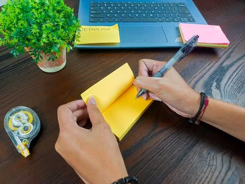 Women write in yellow notes, mock up yellow notes. Women's hands write notes Stock Photos