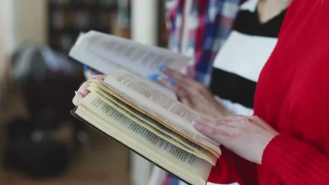 Women's beautiful hands flip through a textbook page, students read books Stock Footage 199792239