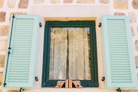 Women's clogs with a large buckle on the side on the window with open shutters Stock Photos