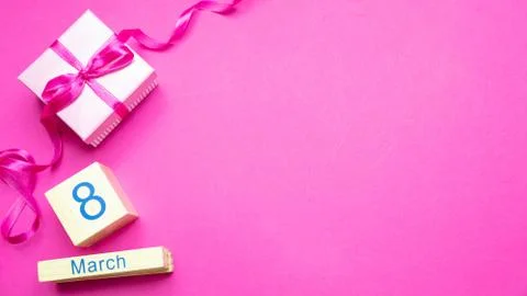 Womens day concept. Gift box with ribbon and date March 8th on wooden cubes a Stock Photos