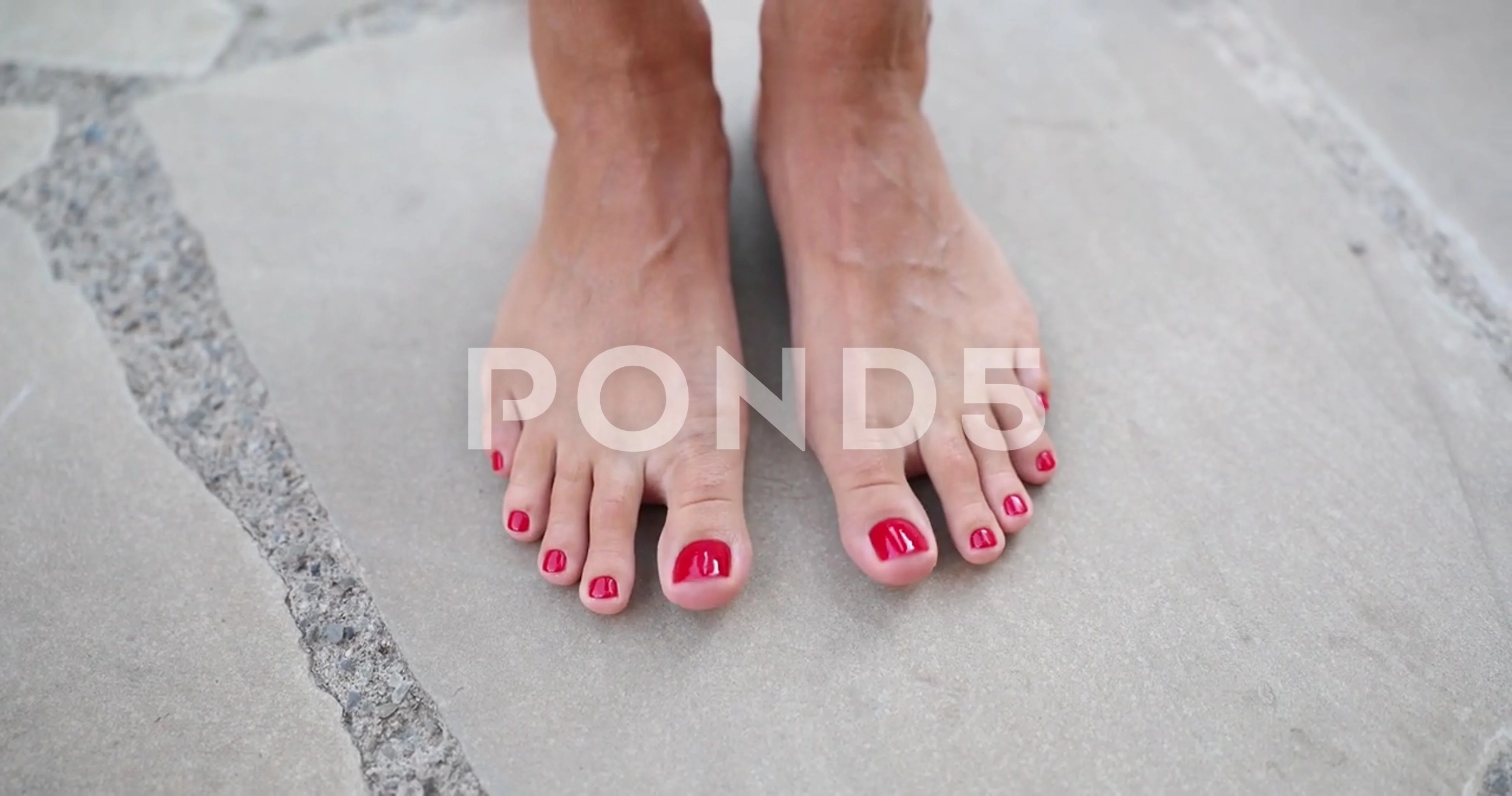 female feet close up toes with red pedicure on a beautiful