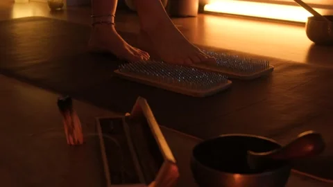 Women's feet stepping on sharp nails for meditation, sadhu wooden board. Yoga Stock Footage 234644085