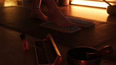 Women's feet stepping on sharp nails for meditation, sadhu wooden board. Yoga Stock Footage 238556286