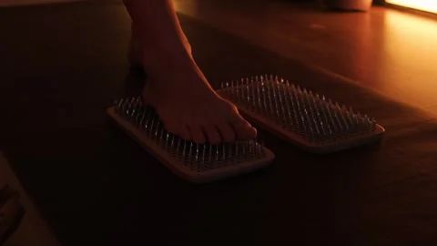 Women's feet stepping on sharp nails for meditation, sadhu wooden board. Yoga Stock Footage 240839323