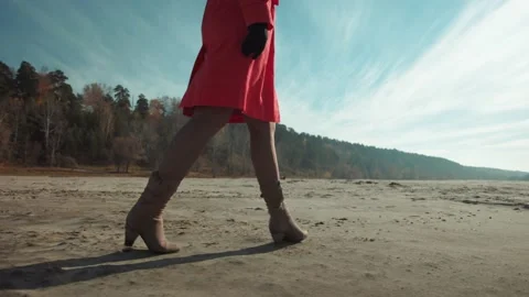 Women's feet walk on the sand Stock Footage