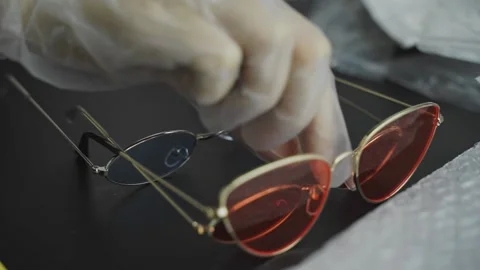 Women's gloved hands put set of sunglasses with colored lenses on table. Video stock 206006311