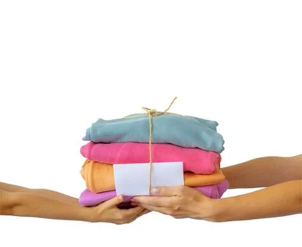Women's hand give a stack of clothes to children's hands. Helping the poor Stock Photos