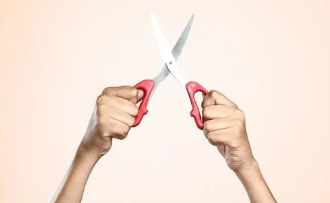 Women's hand with scissors on plain background Foto stock