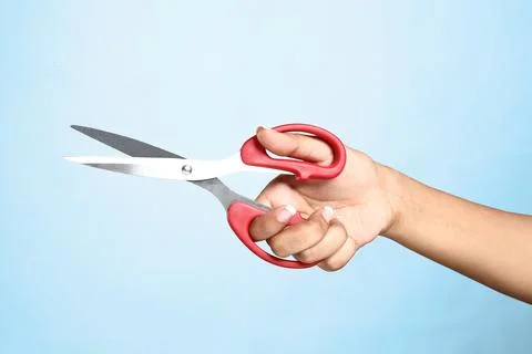 Women's hand with scissors on plain background Stock Photos