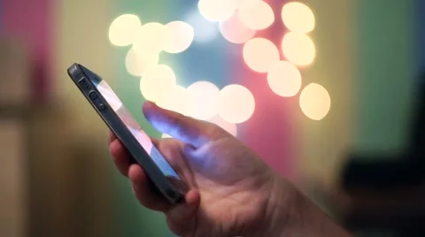 Womens hand using cellphone on the bokeh Stock Footage 56479983
