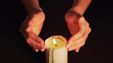 Women's hands above the burning candle close-up. Magic fire, the witch predicts Stock Footage 124860853