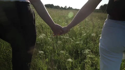 Women's hands are connected against the background of a wild meadow with tall Stock Footage 159809233