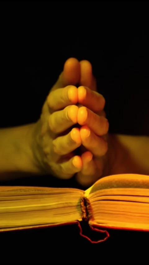 Women's hands are folded prayerfully on the Holy Scriptures. Religion. Stock Footage 293138054