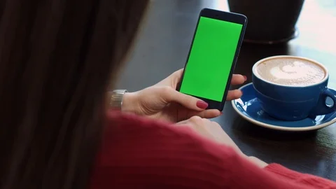 Women's Hands Are Looking for Information in the Phone With a Green Screen Stock Footage 87875998