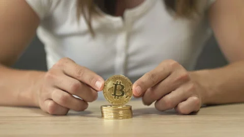 Women's hands are playing with a stack of bitcoins. Stock Footage 205196842