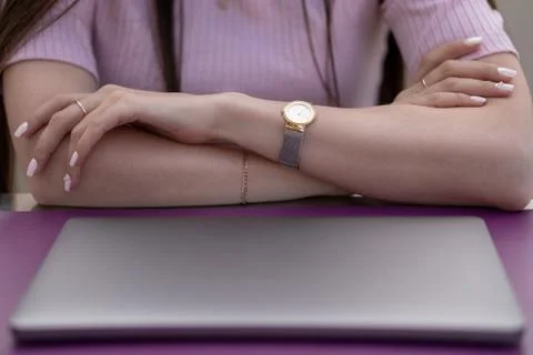 Women's hands are on the table in front of a closed laptop Foto stock