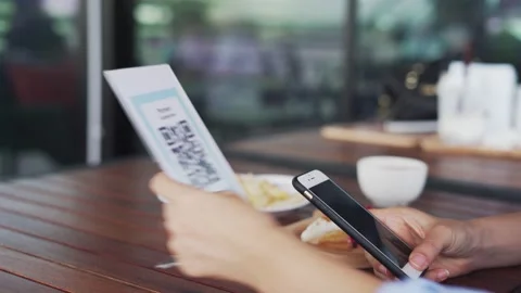 Women's hands are using  the phone to scan the qr code to select food menu. S Stock Footage 139021545