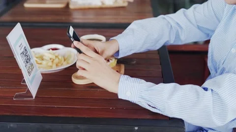 Women's hands are using  the phone to scan the qr code to select food menu. S Stock Footage 139021777