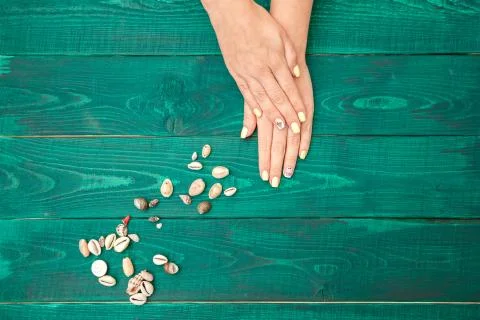 Women's hands with a beautiful manicure with a summer pattern and shells on a Foto stock