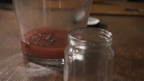 Women's hands begin to pour liquid into the small bottle through the filter Stock Footage 89675117