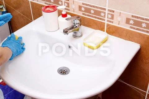 Women's hands in blue gloves clean the sink Stock Photos