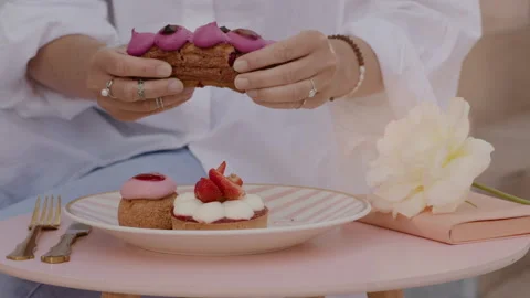 Women's hands break an eclair with berry filling. Stock Footage 233780270