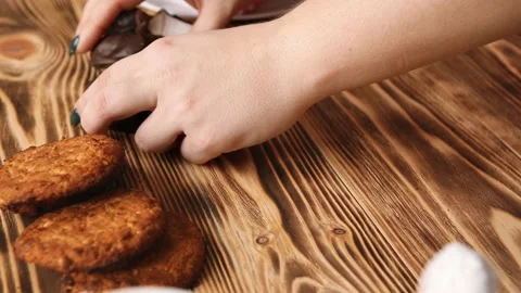 Women's hands break marshmallows in chocolate Stock Footage 86170497