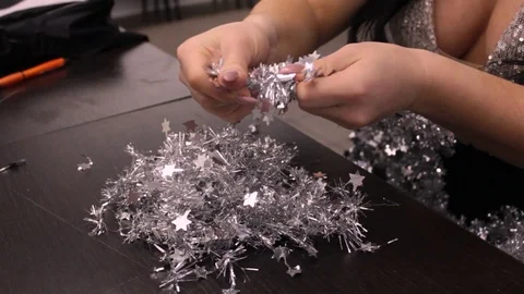 Women's hands break tinsel into small pieces of confetti Stock Footage 120415776