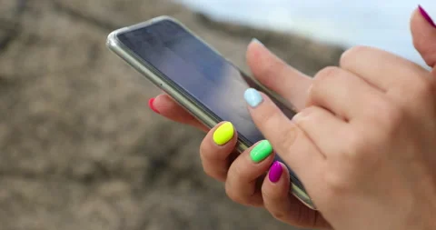Women's hands with bright, multi-colored manicure use  mobile phone 스톡 동영상 135495178