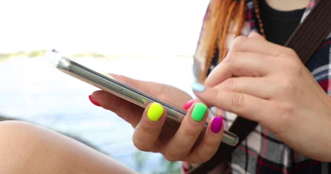 Women's hands with bright, multi-colored manicure use  mobile phone Stock Footage 135495185