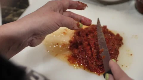 Women's hands chop a tomato finely for sauce. Video stock 237702653