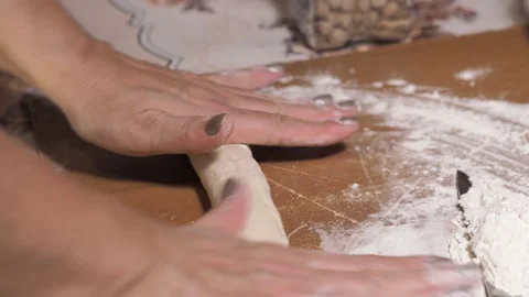 Women's hands close-up, roll out the raw dough into an elongated shape Stock Footage 132898028